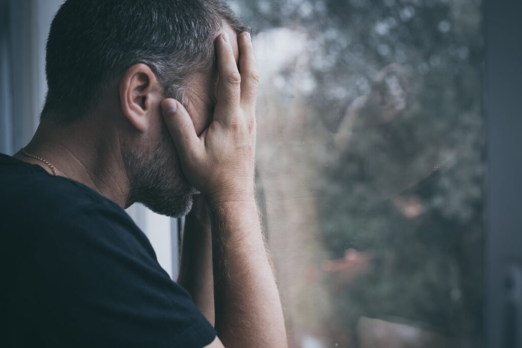 portrait-one-sad-man-standing-near-a-window