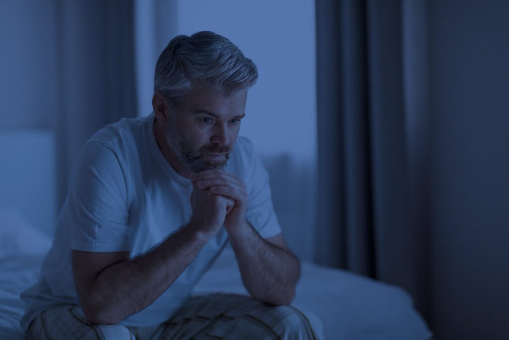 stressed-mature-man-sitting-on-bed-at-night